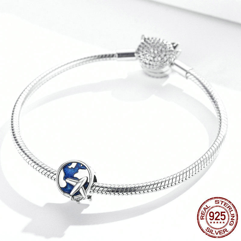 Elegant Travel Charm attached to a sterling silver bracelet, symbolizing adventure and protection. A must-have accessory for travel enthusiasts.