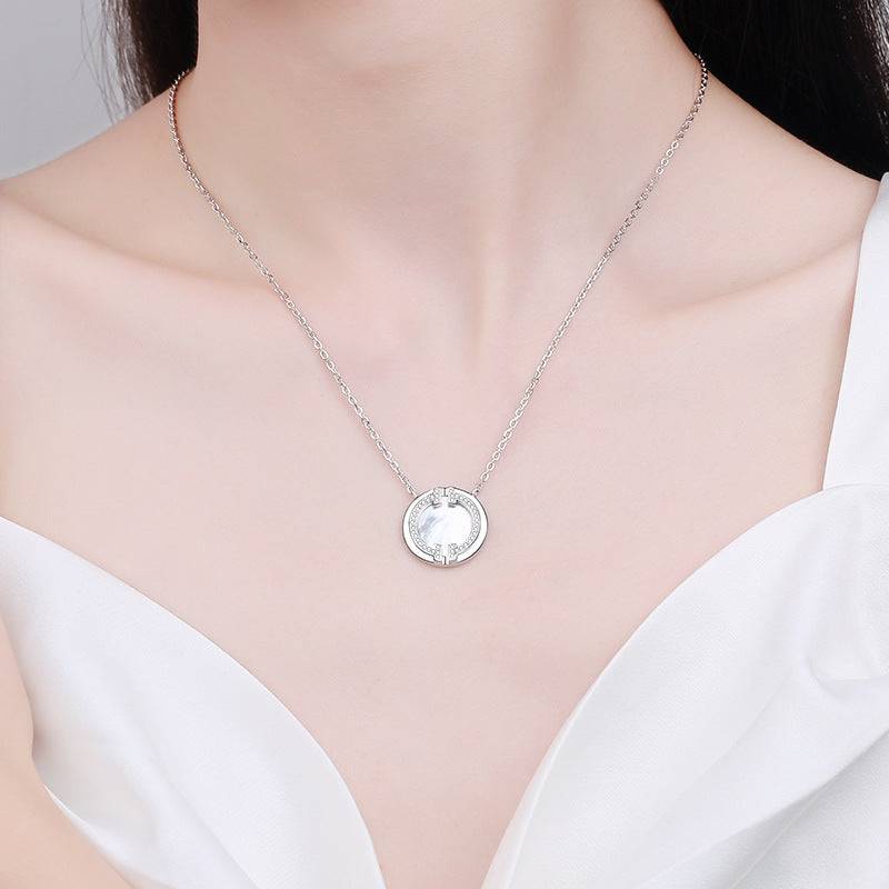 Elegant circular moissanite necklace worn on a model, showcasing its delicate silver chain and radiant round pendant.