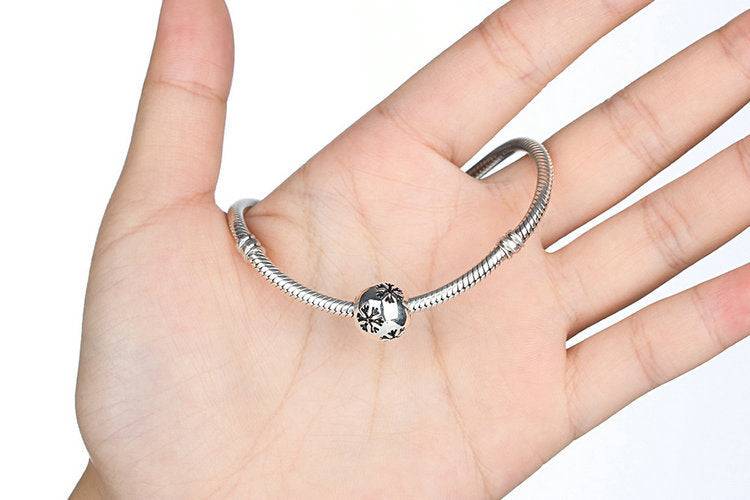 Silver Snowflake Bead Charm on a snake chain bracelet, featuring intricate winter-themed design in 92.5% silver. Ideal for seasonal jewellery lovers.
