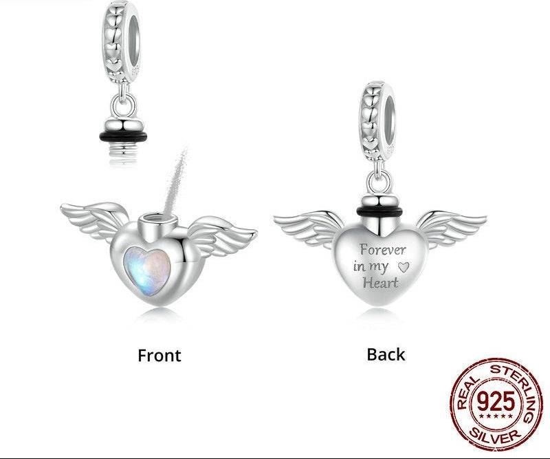 Silver heart-shaped pendant with wings and 'Forever in my Heart' engraving on a white background.