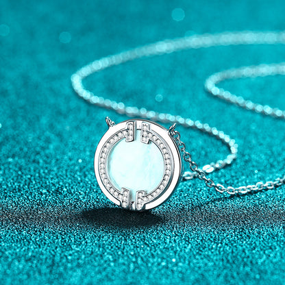 Circular moissanite necklace displayed on a glittering turquoise background, highlighting its intricate design and brilliance.