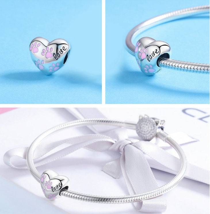 Pink Paw Charm displayed on a silver bracelet, showcasing its heart shape, pink paw prints, and elegant sterling silver finish.