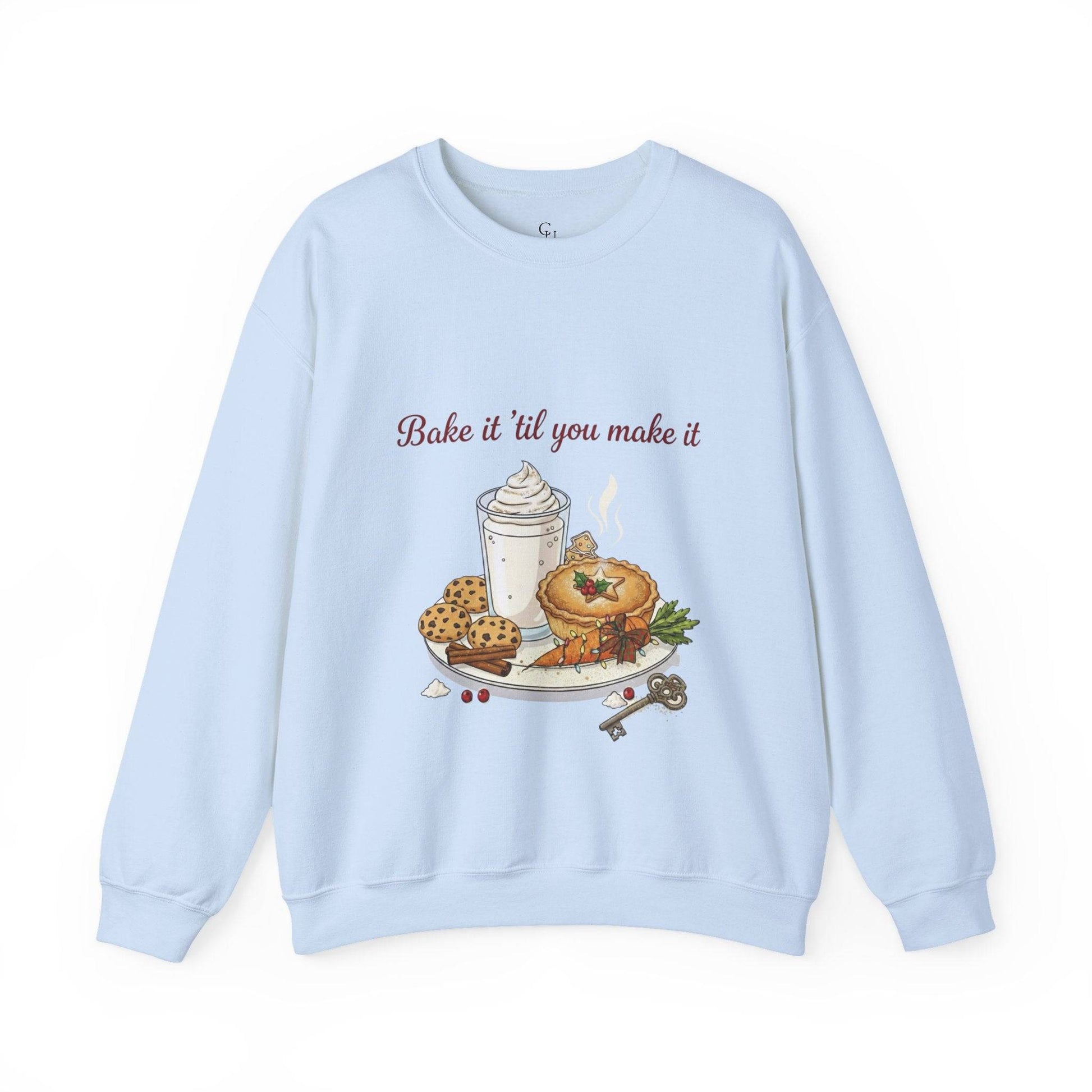 Women’s Sweatshirt - “Bake it ‘til you make it” in light blue with festive pie, cookies, and whipped drink graphic, perfect for cozy winter fashion.