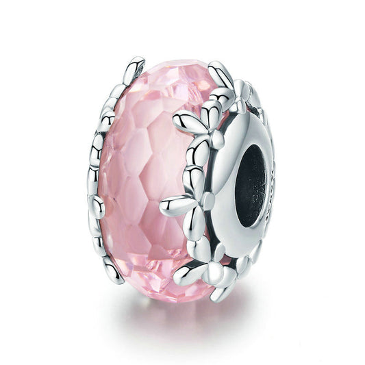 Silver charm with pink gemstone on a white background