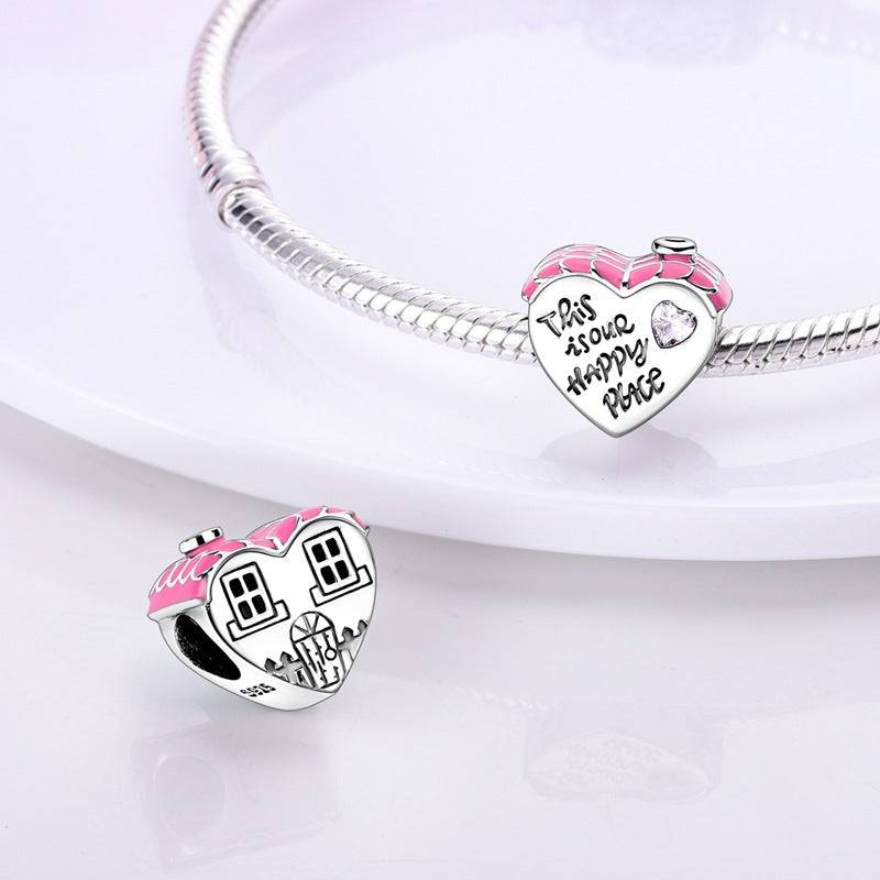 Heart-shaped charm with house design and pink roof