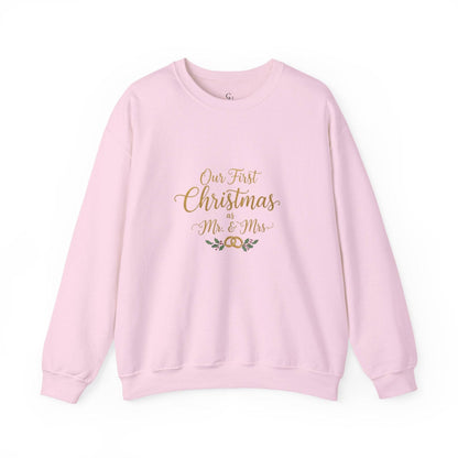 His/Hers Newlyweds Sweatshirt in pastel pink with 'Our First Christmas as Mr. & Mrs.' gold embroidery. Cozy unisex crewneck for holiday gifting.