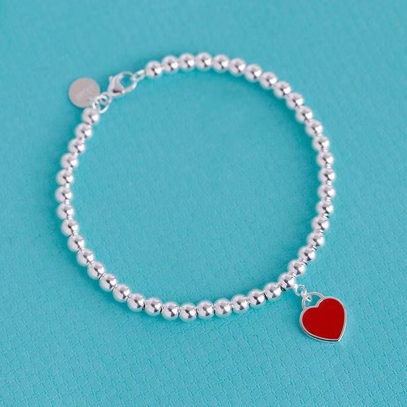 Silver bracelet featuring red heart tag