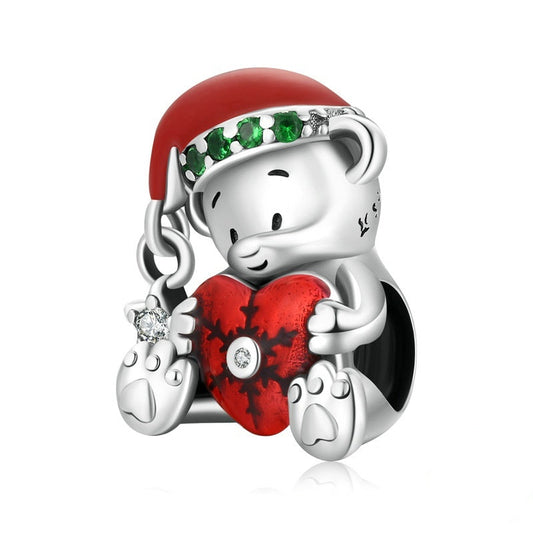 Silver bear charm with red hat and heart, featuring green gemstones and a diamond, on a white background.