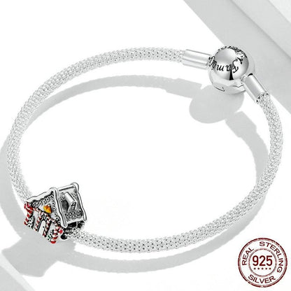 Christmas House Charm on sterling silver bracelet featuring a festive winter cottage design with red and yellow accents. Ideal for holiday jewelry collections.
