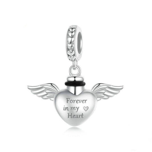 Silver heart-shaped pendant with wings and 'Forever in my Heart' engraving on a white background.