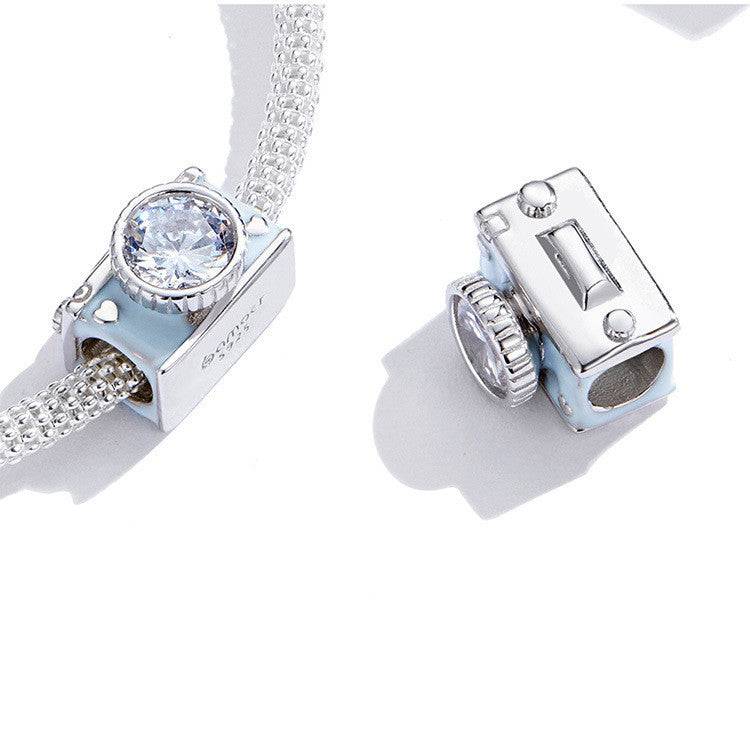 Close-up of camera charm on bracelet