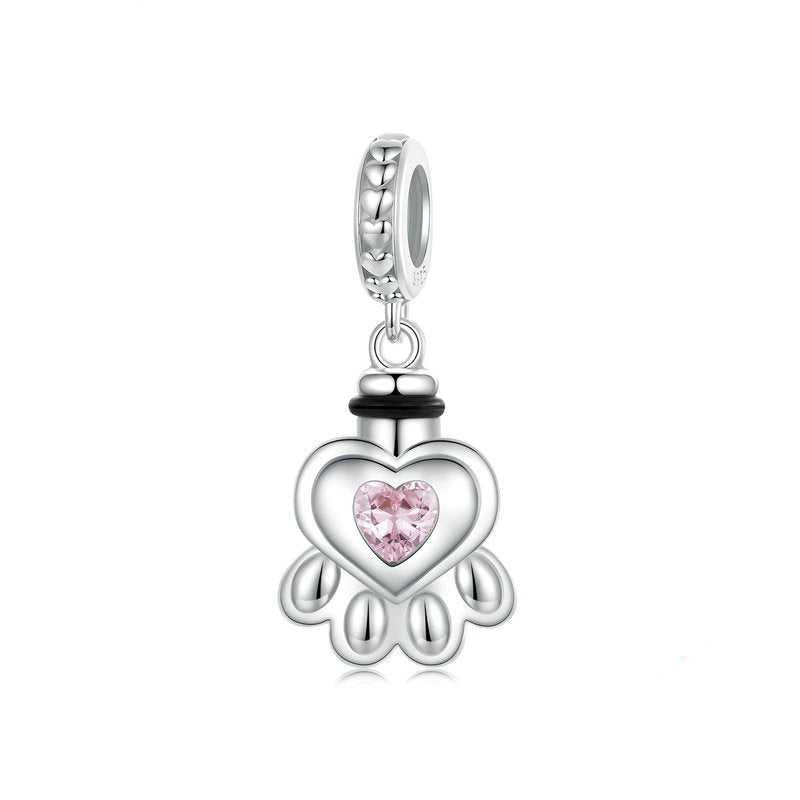 Silver charm with a pink heart-shaped gem on a white background