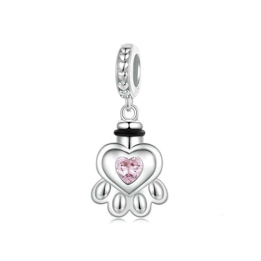 Silver charm with a pink heart-shaped gem on a white background
