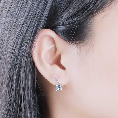 Sky Blue Topaz Earrings - Silver Craftsmanship worn on ear, demonstrating elegant fit and radiant gemstone appeal for everyday or formal wear.
