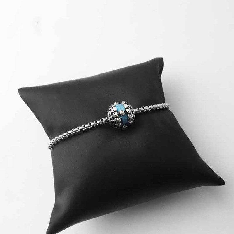 Bracelet with turquoise skull charm on black cushion